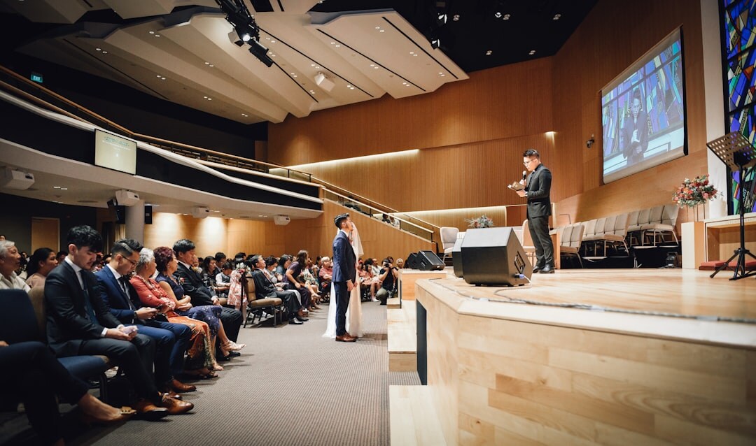 Speaker presenting to a large engaged audience at a professional event